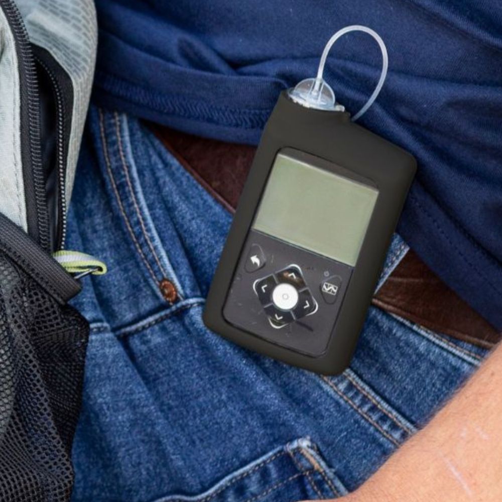 A man wearing a Black Medtronic Insulin Pump Gel Skin with Medtronic pump in it on his jean waist band. 