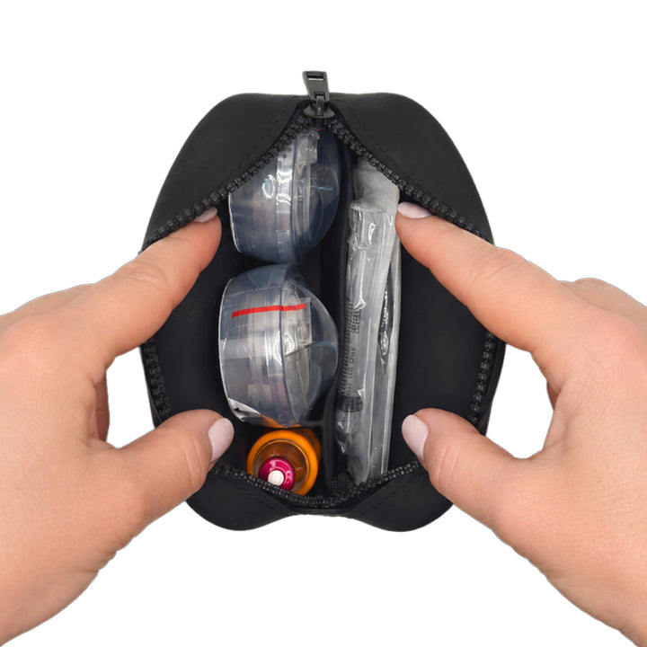 Black Tandem Protective Travel Case with Tandem supplies, held open by hands on a white background
