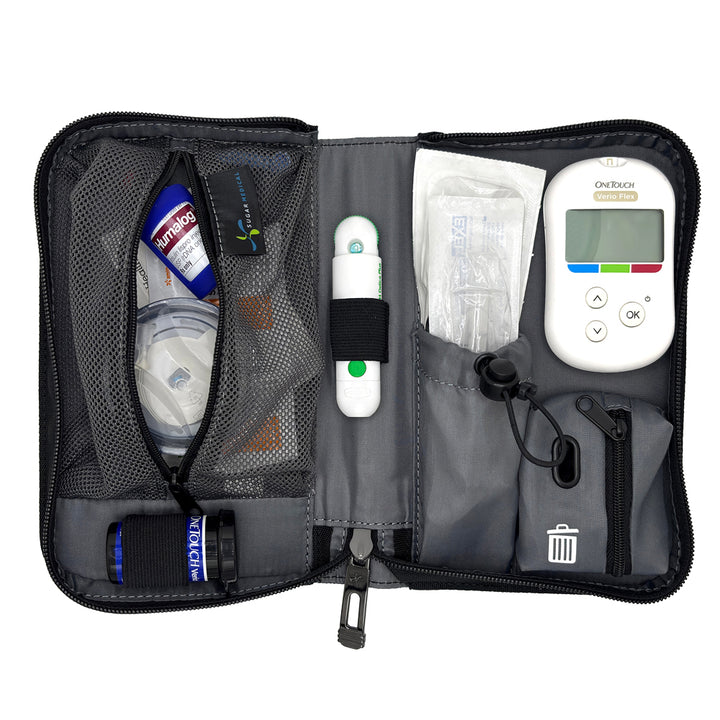 An open gray and black diabetes management kit organizer bag, showing its interior compartments filled with a blood glucose meter, test strips, a lancet, a small bottle, and other medical supplies on a white background.