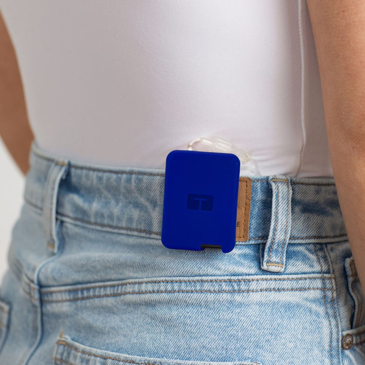 Girl wearing a white tee, with a blueTandem Mobi EZ-To-Charge Clip attached to the back waistband of her jeans. 