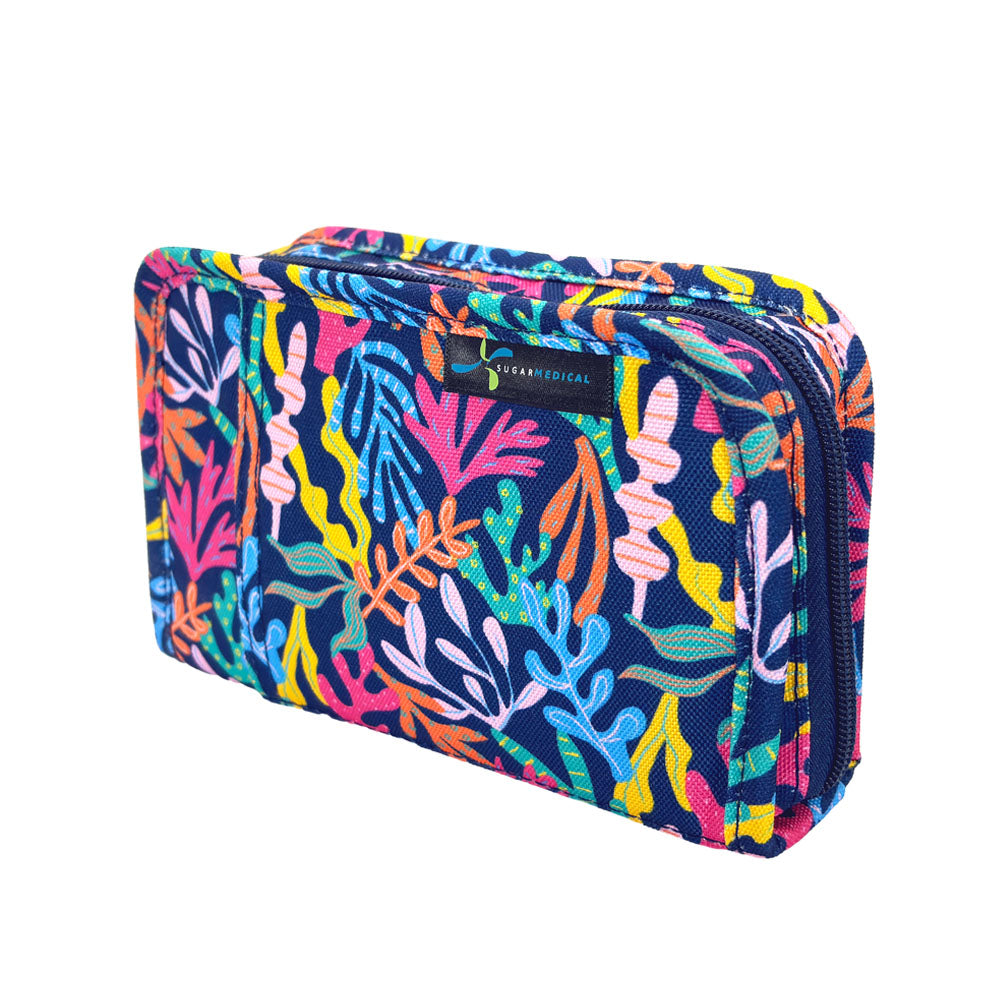 A diabetes supply case by The Sugar medical featuring a vibrant, multicolored coral pattern on a navy blue background, shown on a plain white background.