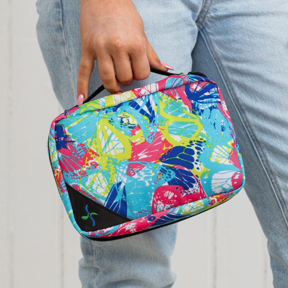 Women with jeans holding the Butterfly Insulated Diabetes Organizer by the handle in one hand. 