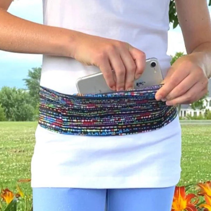 Girl wearing the Confetti Bandi Wear Pocket Belt around waist and pulling the phone out. 