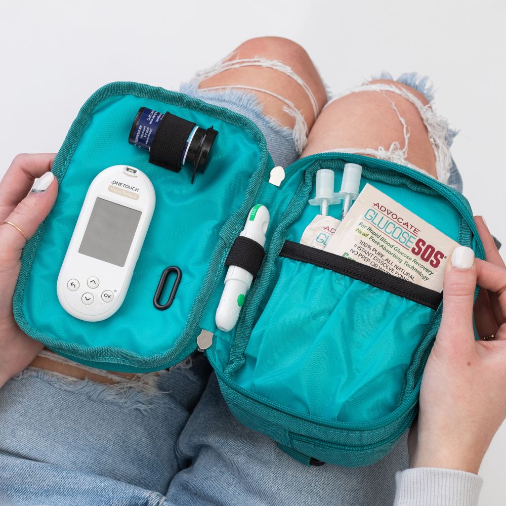 Diabetes Insulated Convertible Belt Bag in turquoise opened on women's lap with diabetic supplies in it.