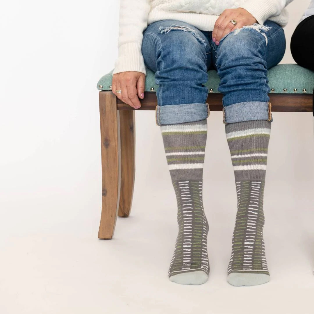 A women sitting on bench wearing Dr. Segal driftwood lines socks.