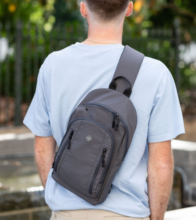 A man wearing a black diabetes sling backpack. 