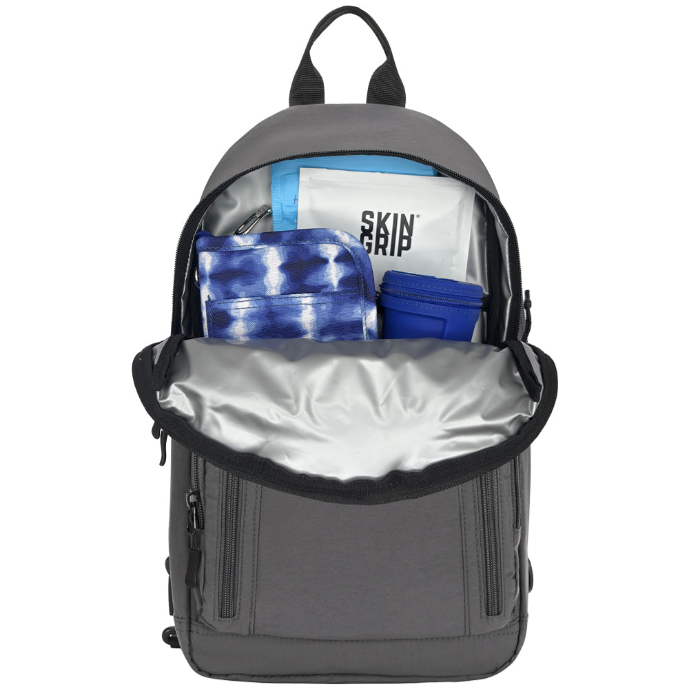 A gray backpack shown open against a white background, revealing its interior and contents including a white bag with 'SKIN GRIP' text, a blue tie-dye pouch, and a blue cup.