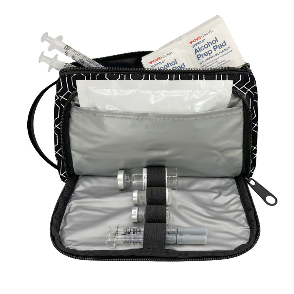 An open black and white patterned medical supply pouch containing a syringe, vials, an alcohol prep pad, and a bandage on a white background.