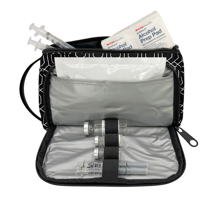 An open black and white patterned medical supply pouch containing a syringe, vials, an alcohol prep pad, and a bandage on a white background.