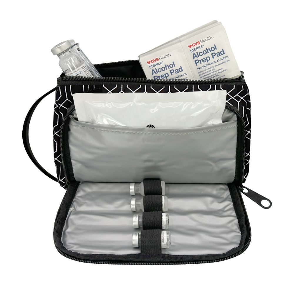 An open black and white geometric patterned travel first aid kit pouch, showing its gray interior with a bottle holder, alcohol prep pads, and a clear plastic bottle.
