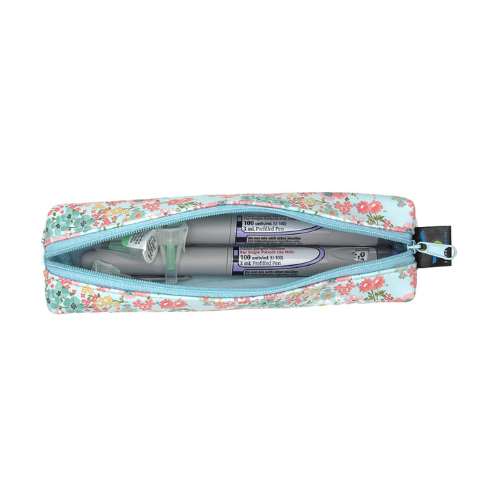 Floral-patterned pencil case with two insulin pens and pen tips inside on a white background