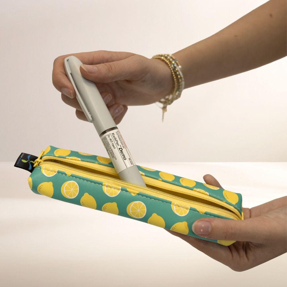 MedMate with lemon pattern held by a hand, with an insulin pen being inserted.