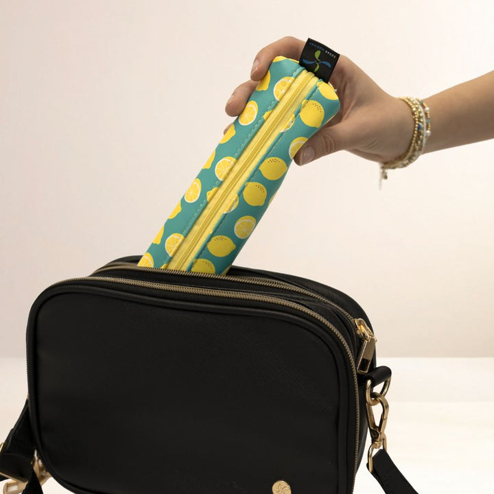 Hand holding a black bag with a yellow and blue lemon design MedMate against a plain background
