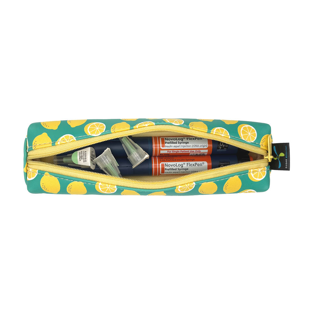 Lemon-patterned slim case open with two insulin pens and pen tips in it. 
