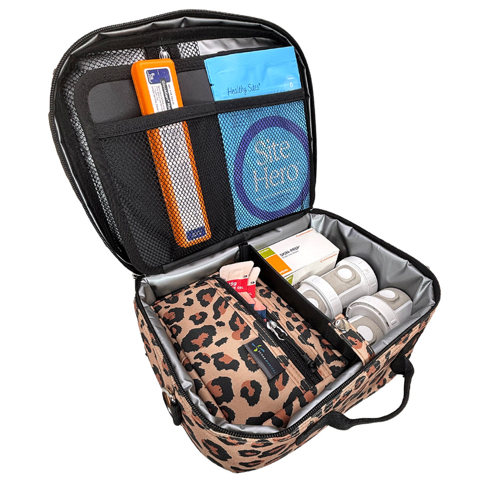 An open leopard-print carrying case with black mesh and fabric compartments, insulin pens, glucose meter, and other diabetes supplies, photographed on a plain white background.