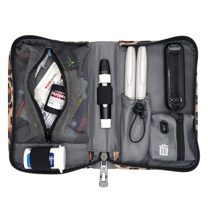 An open gray and black medical organizer pouch containing various diabetes management tools, including a white OneTouch glucose meter, pens, a thermometer, and storage compartments, shown on a white background.