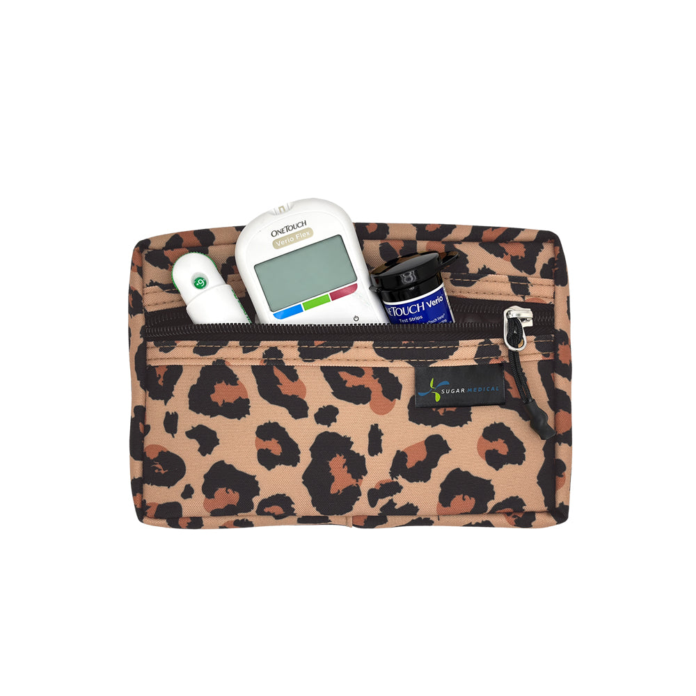 A leopard print zippered travel health pouch containing a glucose meter, thermometer, and insulin bottle, shown on a plain white background.