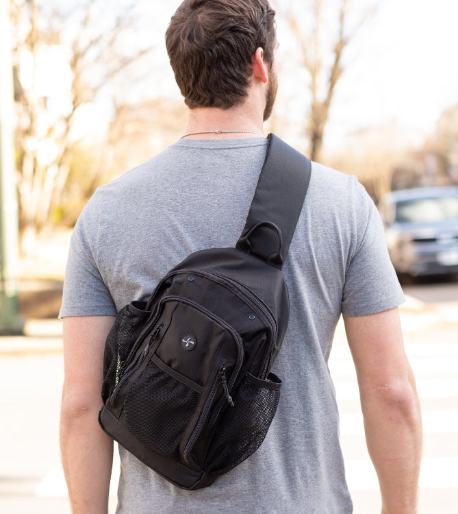 A man wearing a black diabetes sling backpack. 
