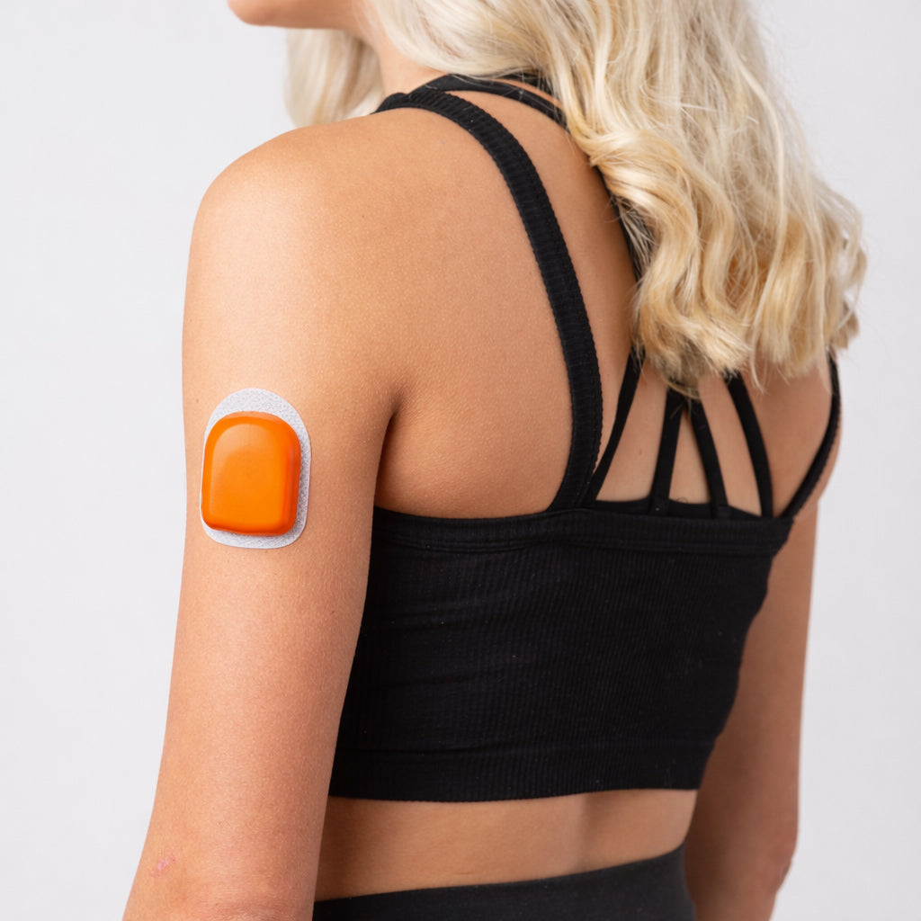 A woman wearing a orange PumpPOP on the outside of her upper left arm