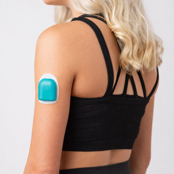 A woman wearing a turquoise PumpPOP on the outside of her upper left arm