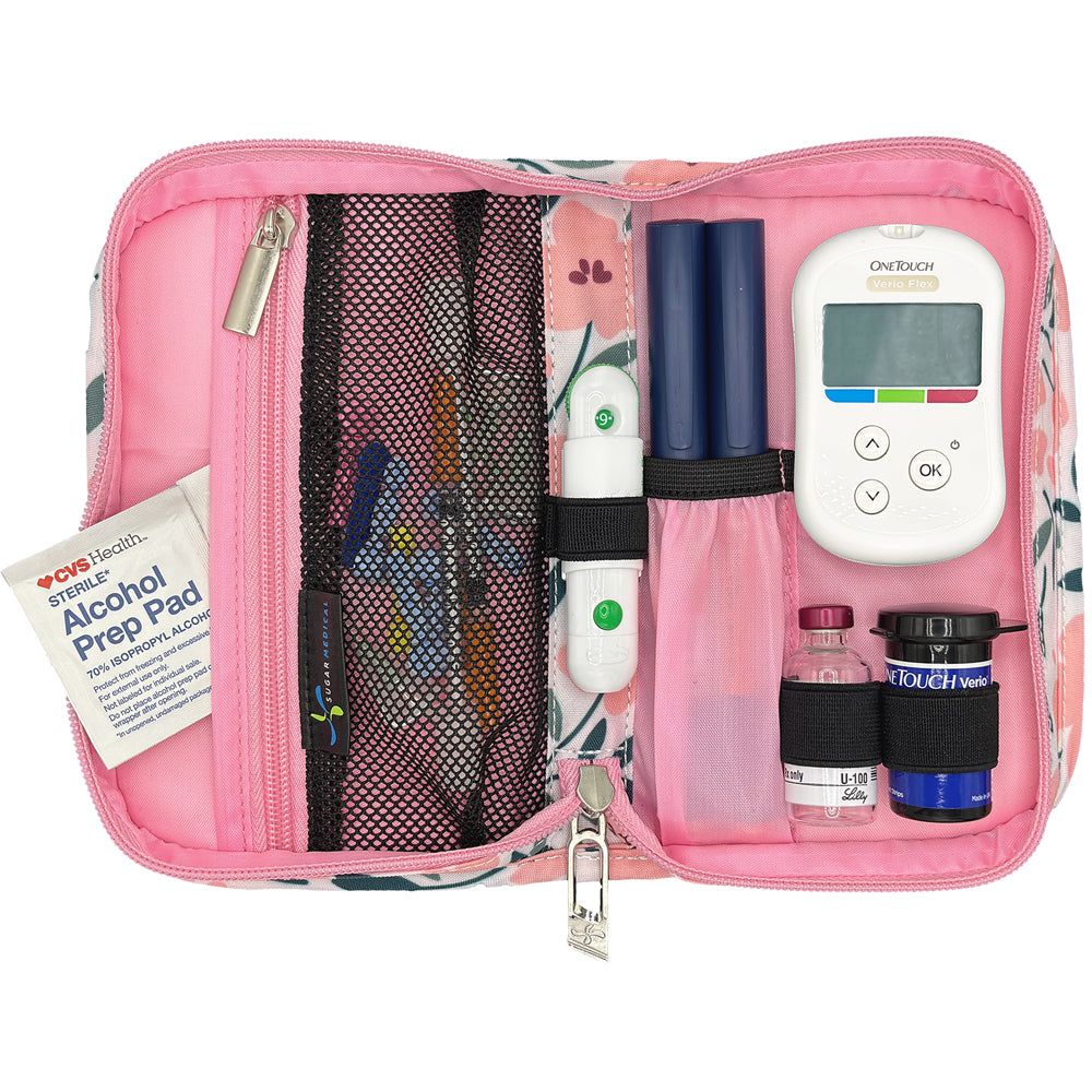 Pink diabetic supply kit with glucose meter, lancet, insulin pens and other diabetic supplies on a white background
