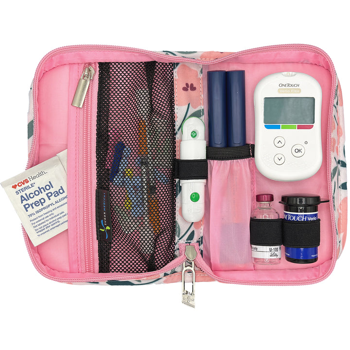 Pink diabetic supply kit with glucose meter, lancet, insulin pens and other diabetic supplies on a white background