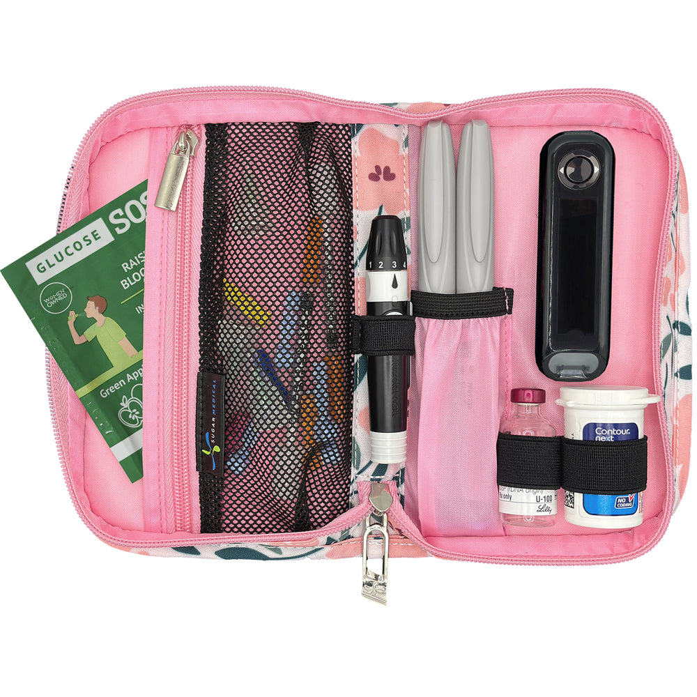 Pink diabetic supply kit with glucose meter, lancet, insulin pens and other diabetic supplies on a white background