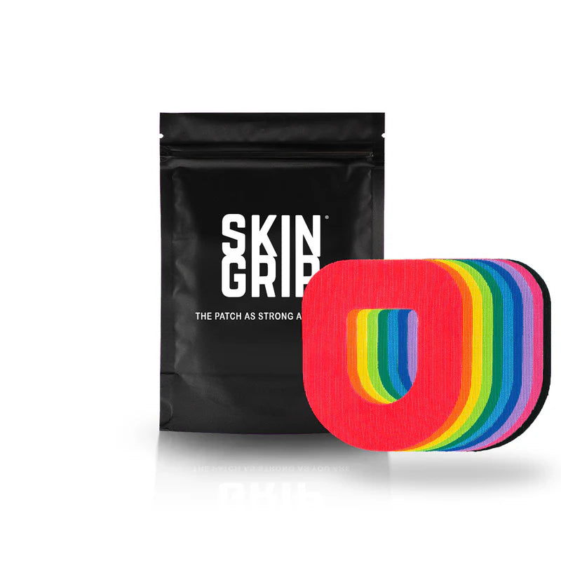 A black package that says Skin Grip containing the 20 adhesive patches and the rainbow colored Omnipod adhesive patches around a white pod.