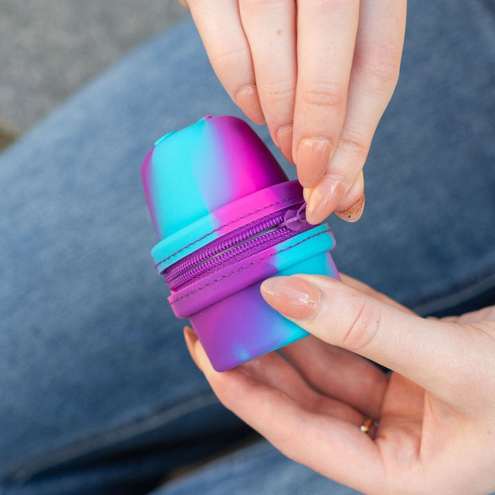 Colorful Libre 3 Travel Protective case with a zipper held by a hand against a blurred background