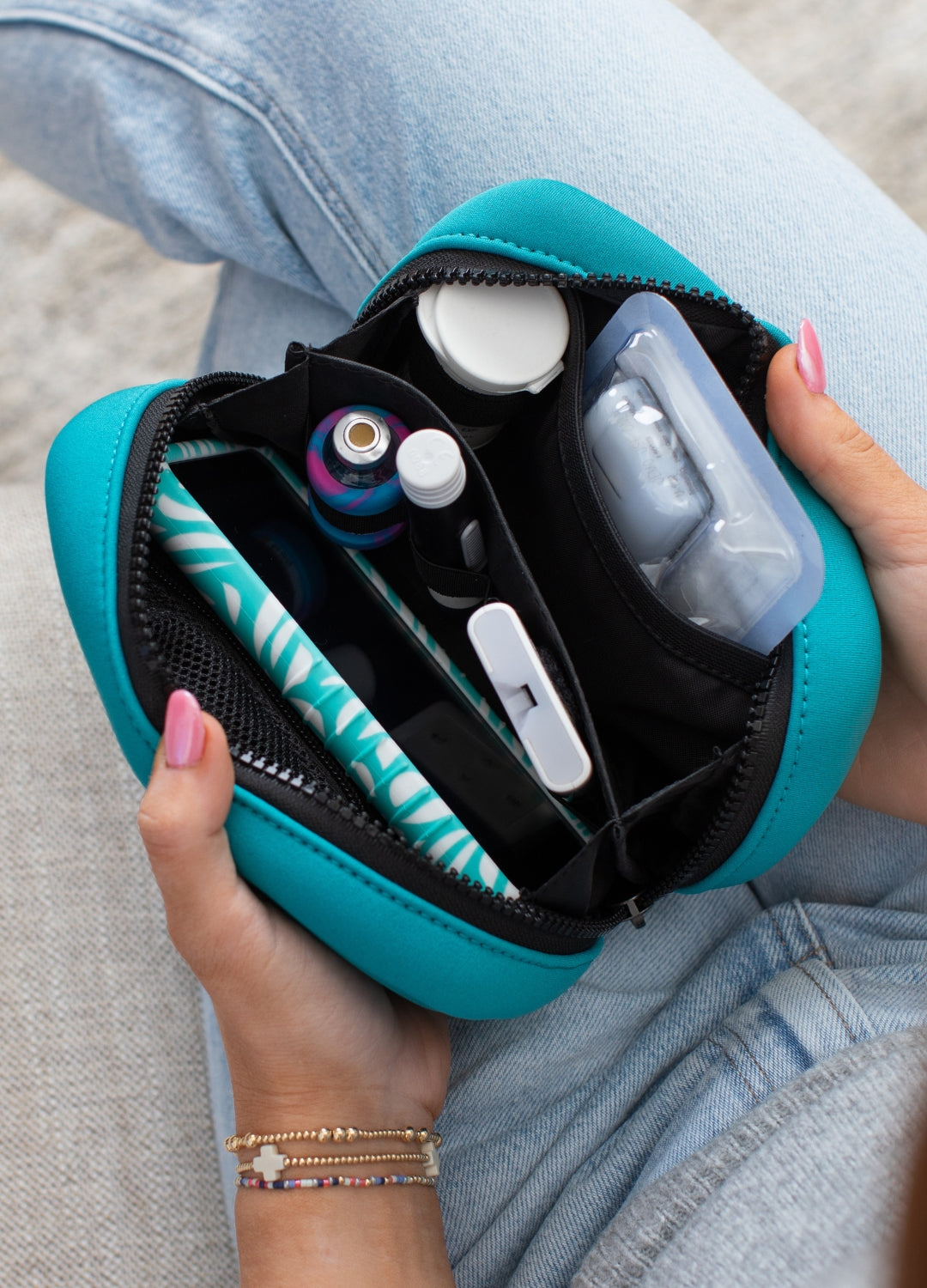 Woman opening a teal Metro diabetes supply case containing Omnipod supplies, including pods and other essentials organized inside