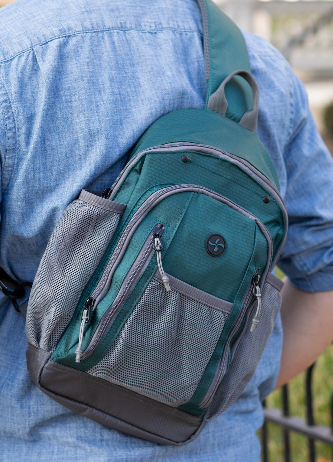 Man wearing a light blue shirt and carrying a Storm Diabetes supply sling backpack over one shoulder.