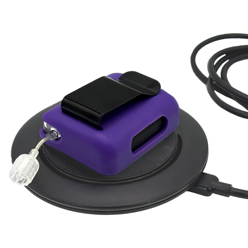 Purple Tandem Mobi EZ-To-Charge Clip with Mobi insulin pump inside the case, lying flat on a charger.