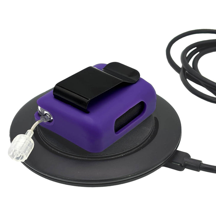 Purple Tandem Mobi EZ-To-Charge Clip with Mobi insulin pump inside the case, lying flat on a charger.