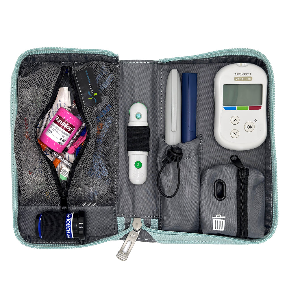 An open gray and black medical organizer pouch containing various diabetes management tools, including a white OneTouch glucose meter, pens, a thermometer, and storage compartments, shown on a white background.
