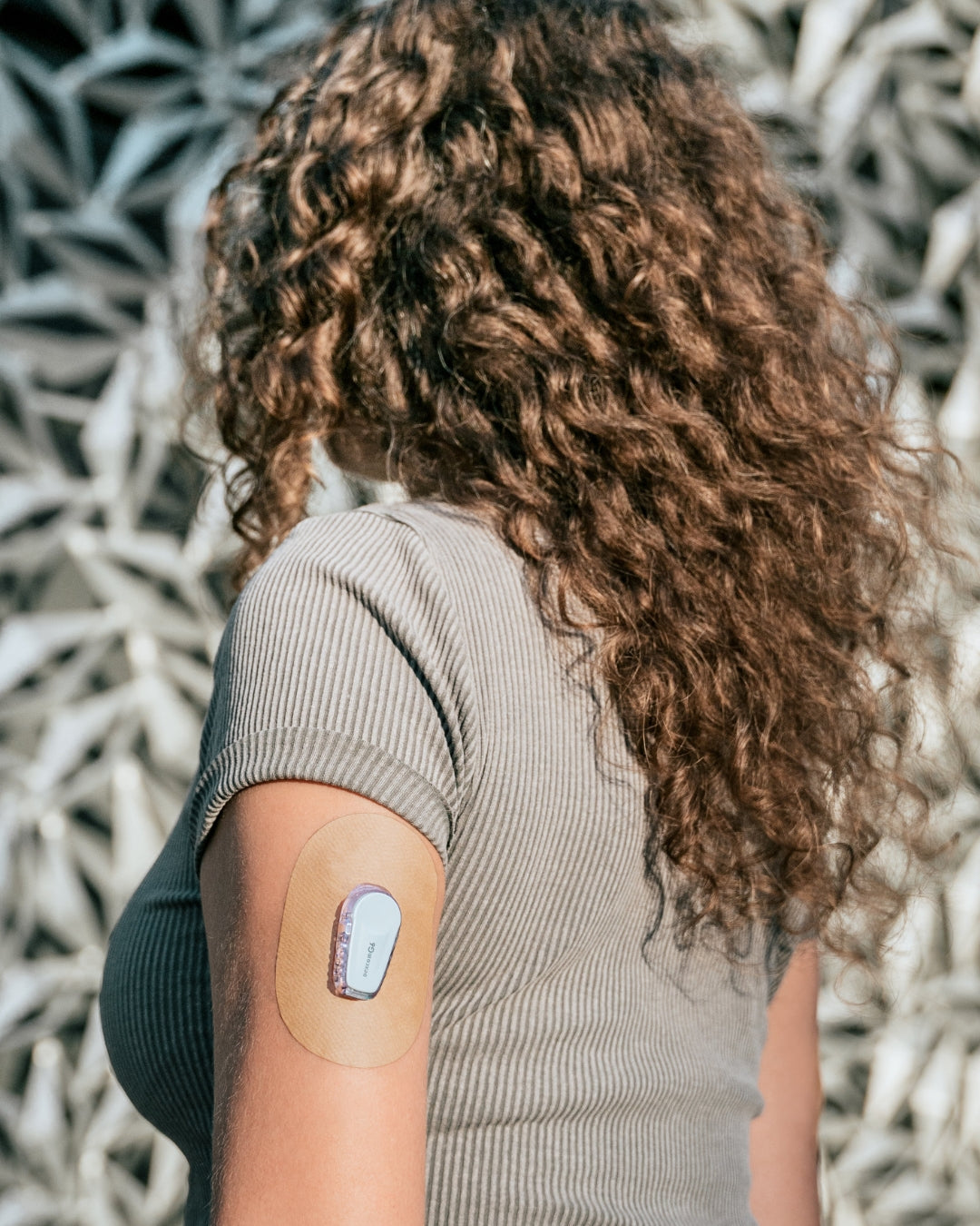 Person with Skin Grip on their arm against a textured wall background