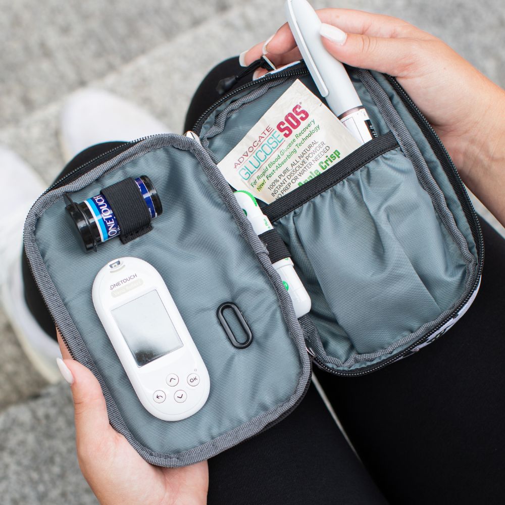 Women pulling out an insulin pen out of the convertible snow leopard diabetes supply case. 