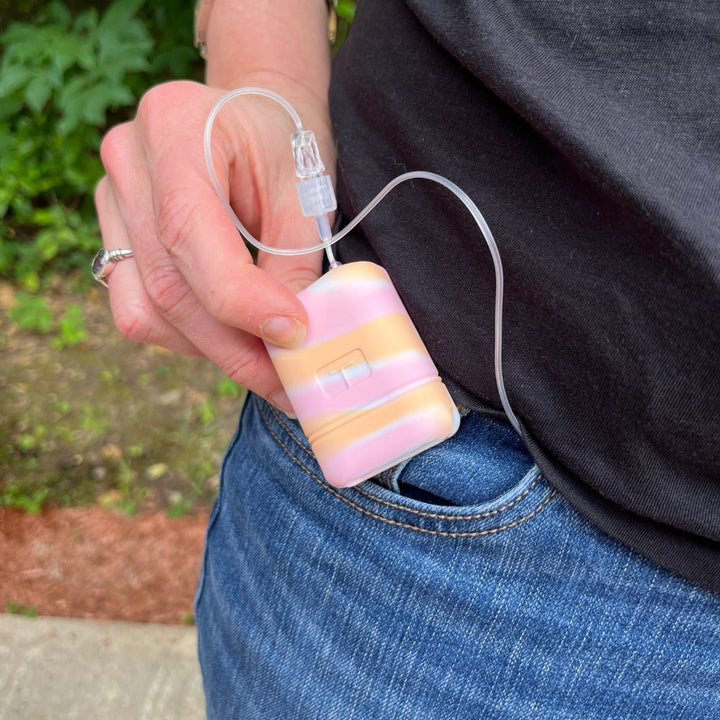 A white, pink and orange sorbet colored Mobi Tandem gel skin in a woman’s hand. 