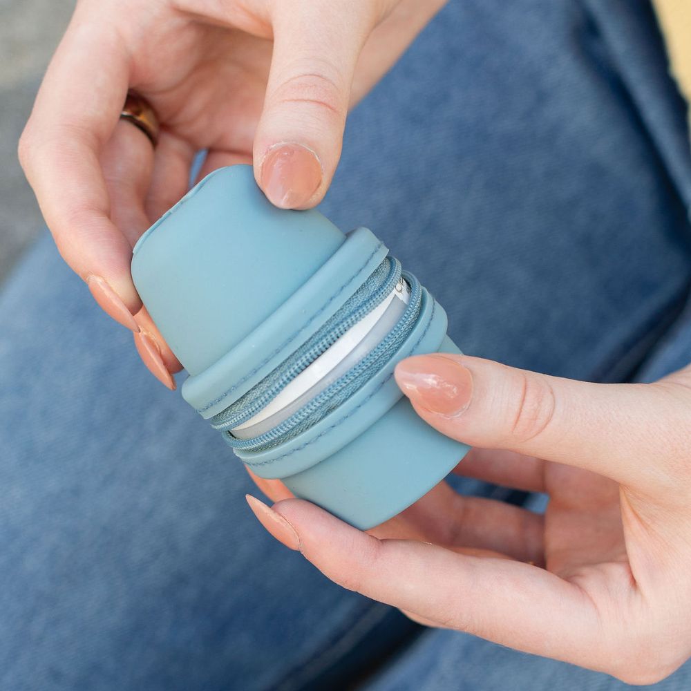 Light blue Libre 3 Travel Protective case held by hands against a blurred background
