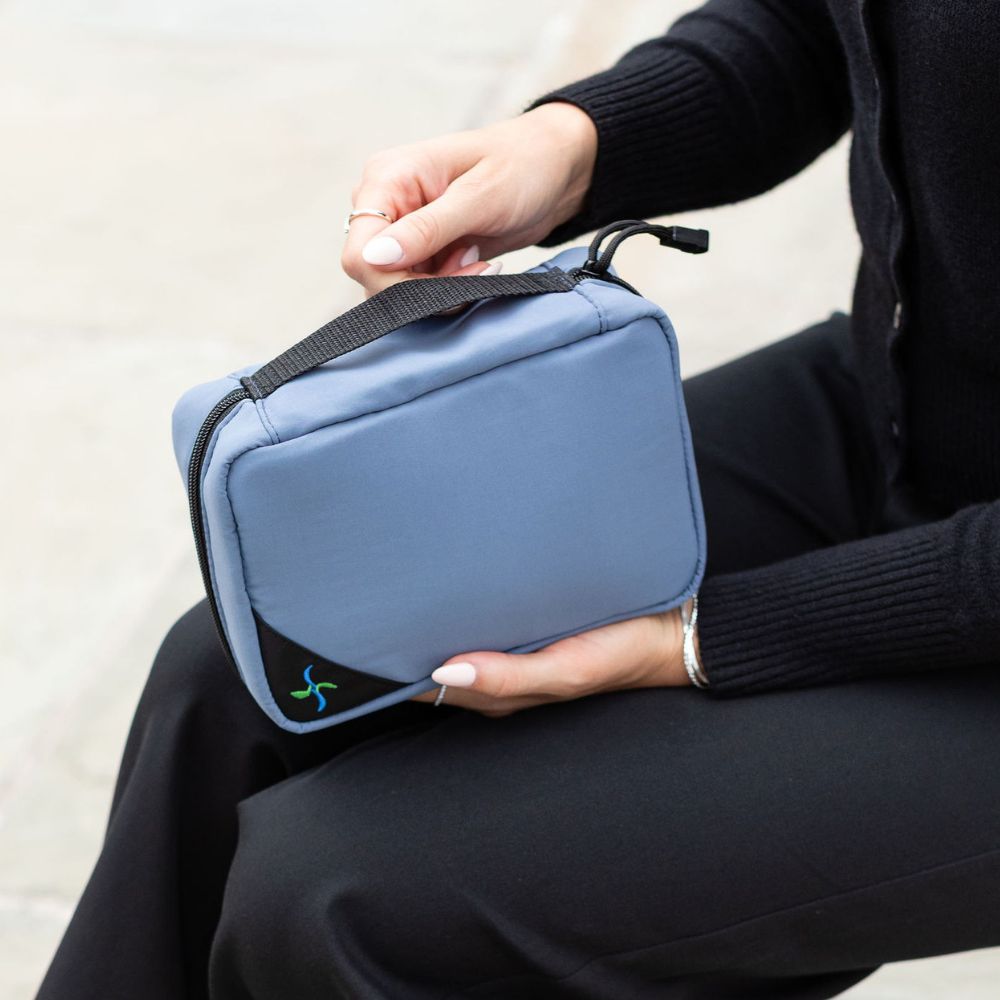 Woman holding a steel blue diabetes organizer on her lap. 