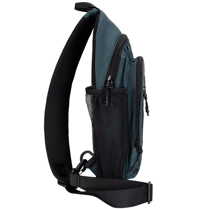 A dark teal and black sling backpack shown from a side profile view against a solid white background, featuring a wide black mesh strap, multiple zippered compartments, and a side mesh pocket.