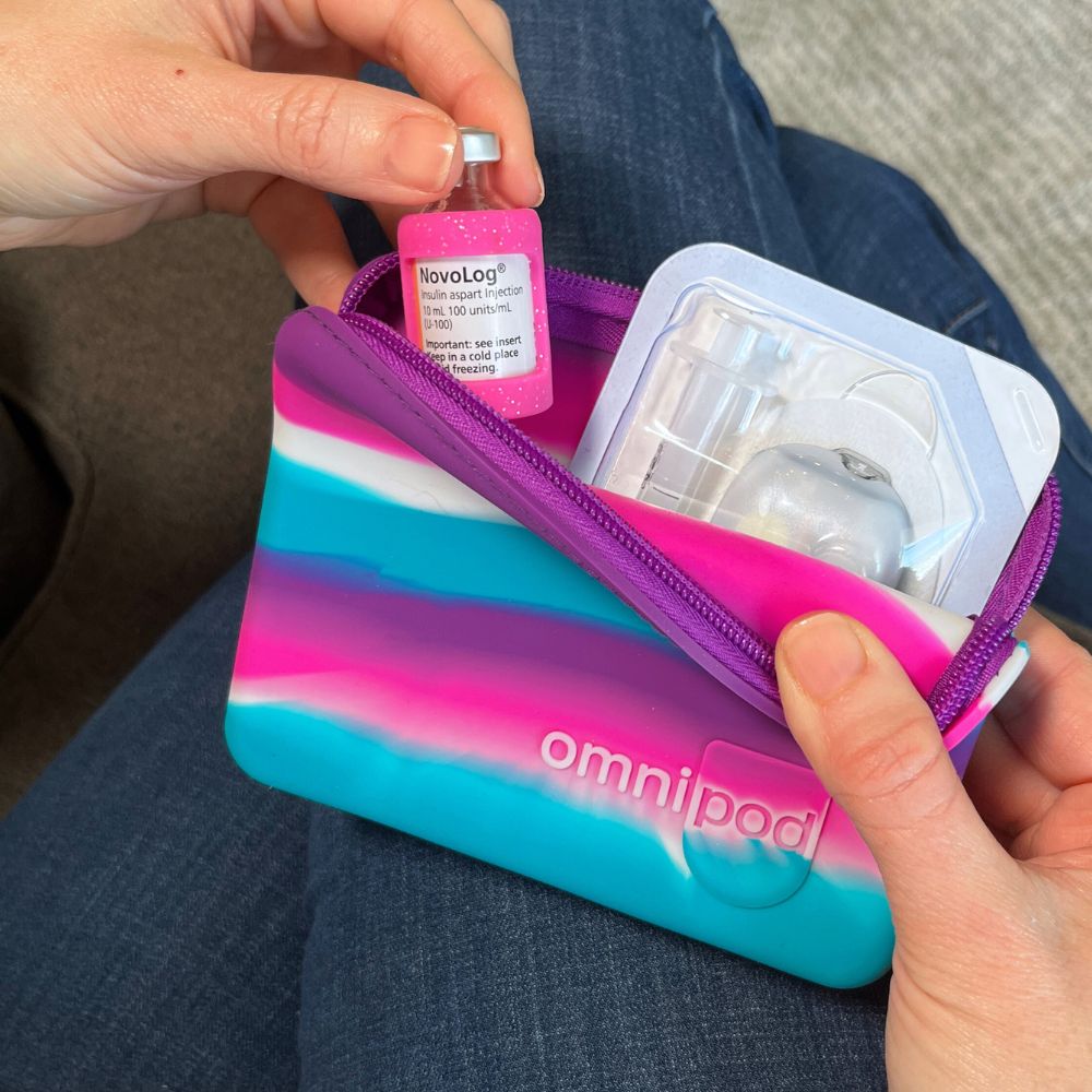 Omnipod device in a colorful case held by a person.
