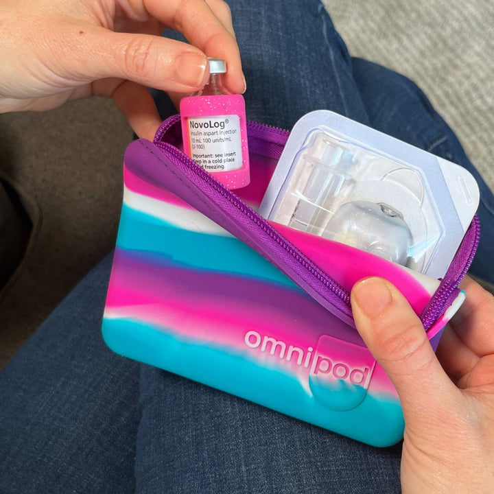 Omnipod device in a colorful case held by a person.