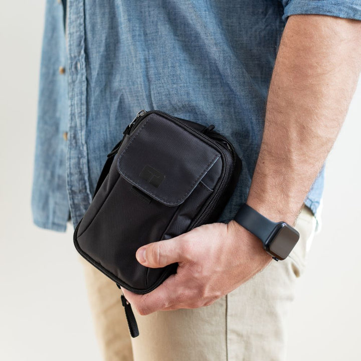 Man holding black tandem supply case in his left hand