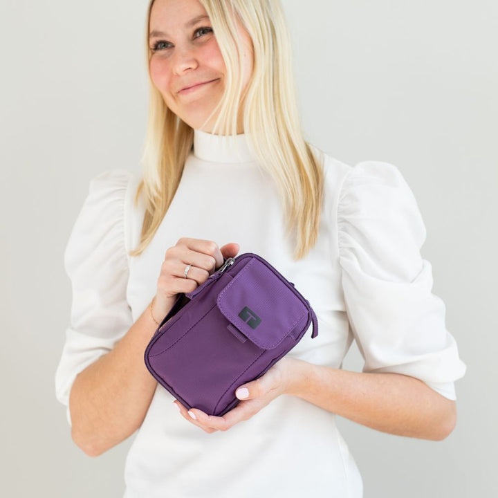 Woman in white shirt holding deep purple tandem supply case 