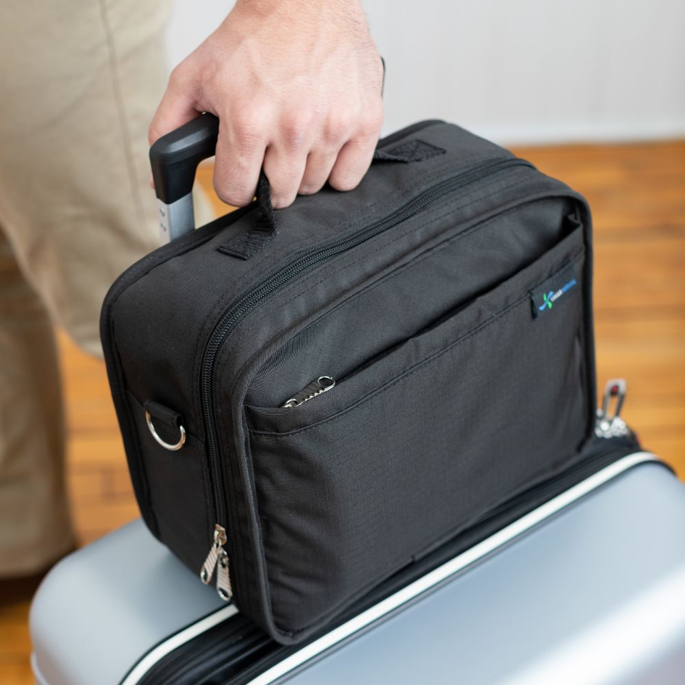 Diabetes Insulated Travel Bag in black carried on a suitcase and being held by the handle. 