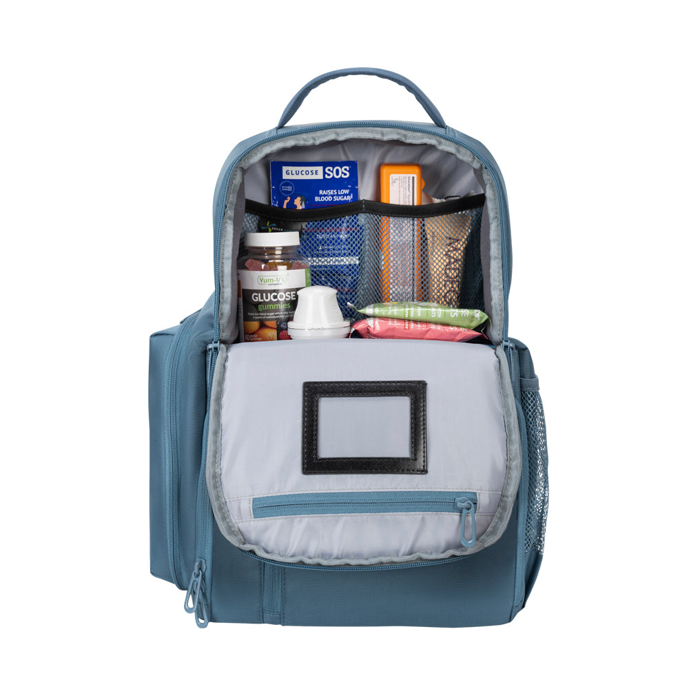 Steel Blue Travel Backpack top pocket open with book, diabetic supply bag, clothes and mesh pocket with chargers. 