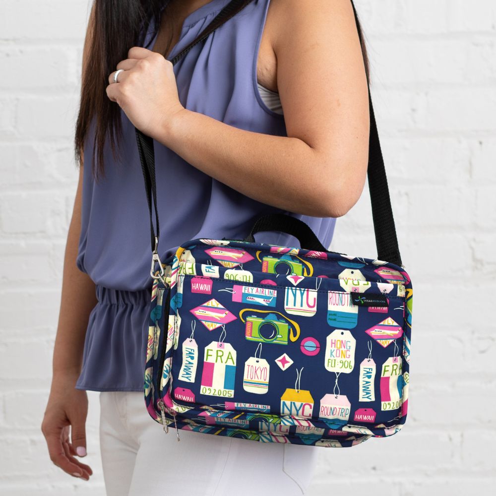 Women in purple top wearing vaca all day insulated diabetes travel bag on her shoulder, highlighting its black shoulder strap. 