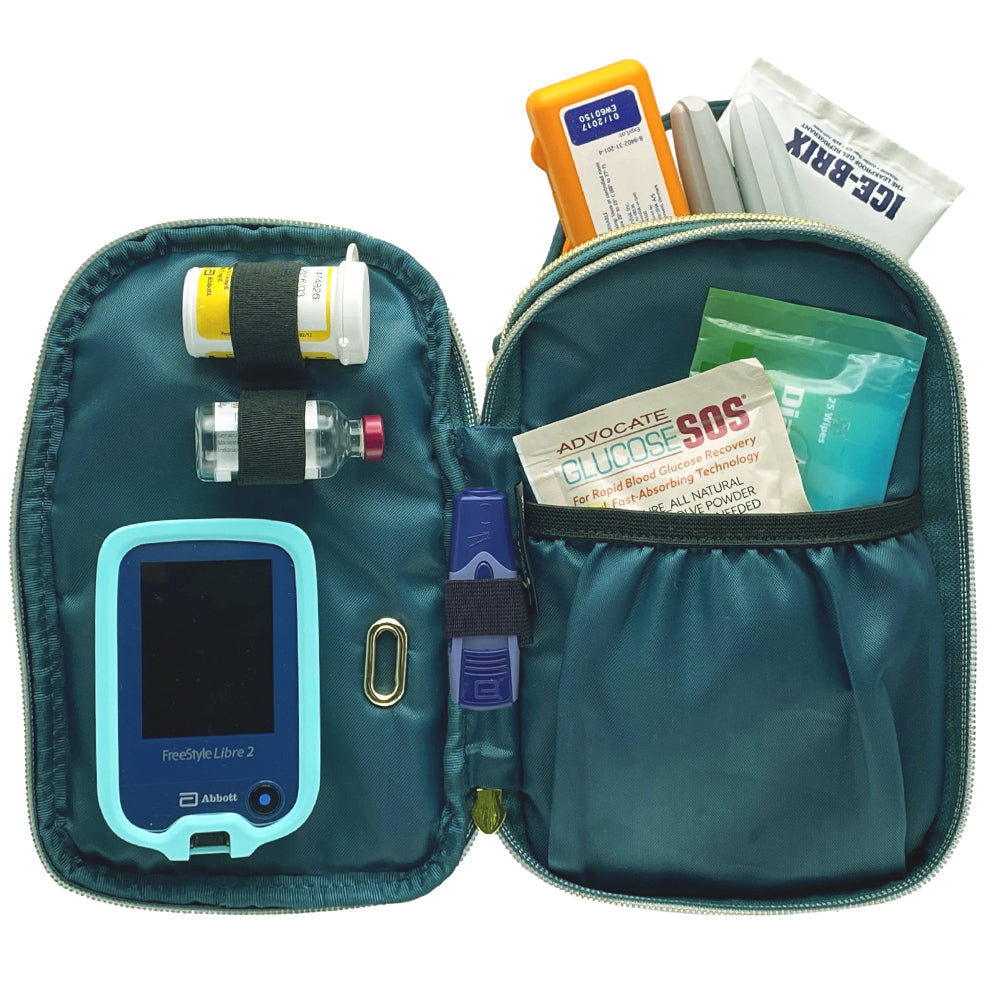 Meredith purse middle section lying flat open showing diabetes supplies in elastic loops and in a nylon pocket. 