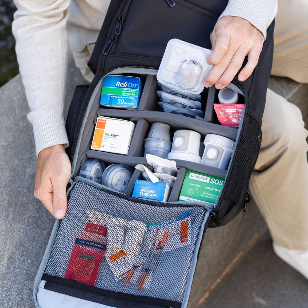 Person opening a black backpack with medical supplies inside