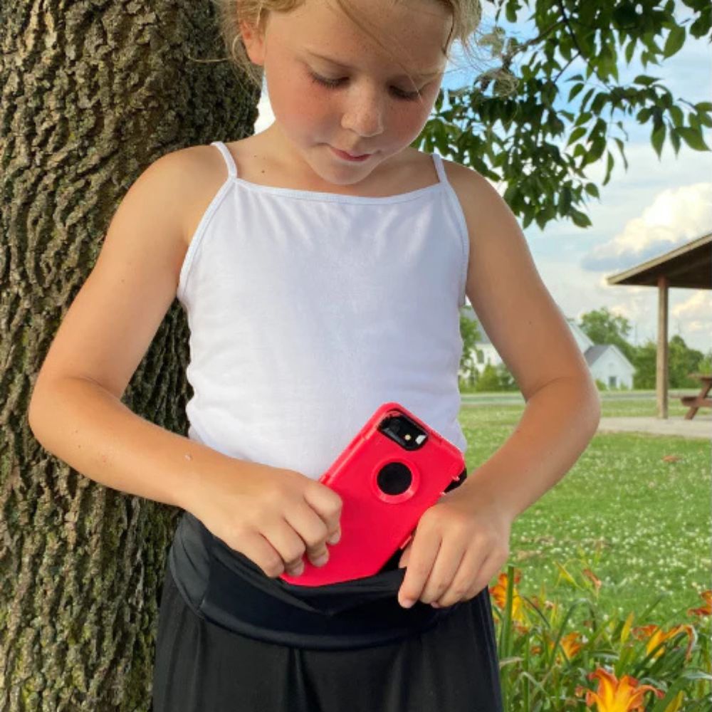 Girl wearing a kids' black Bandi Wear Pocket Belt, pulling a phone out of the pocket, showcasing its convenient and secure design for carrying essentials.